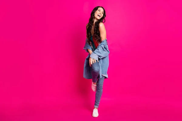 Full längd foto av söta charmiga ung kvinna bär jeans jacka promenader skrattar isolerad ljus rosa färg bakgrund — Stockfoto
