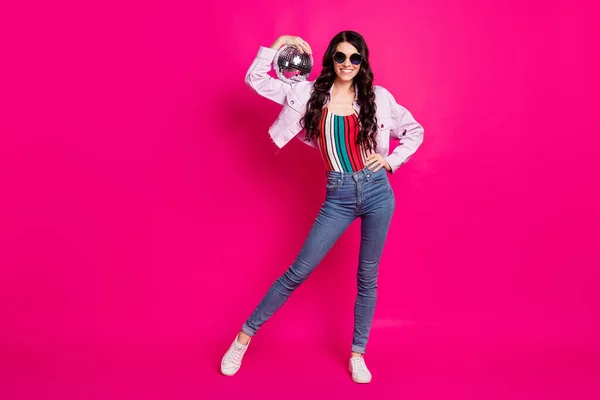 Full size φωτογραφία της αισιόδοξης μελαχρινή κυρία κατέχουν disco μπάλα φορούν γυαλιά top jeans σακάκι sneakers απομονώνονται σε ροζ φόντο — Φωτογραφία Αρχείου