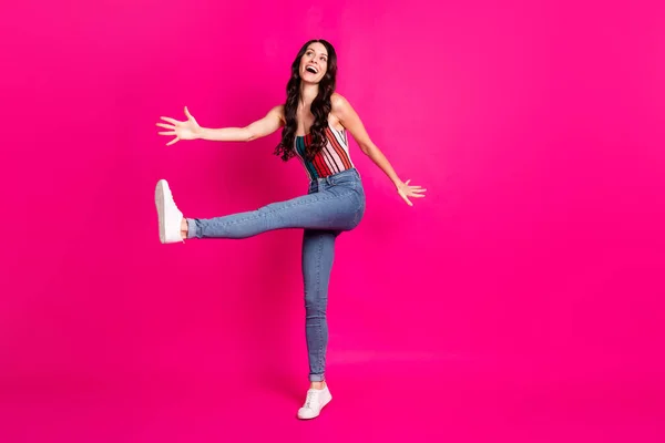Full size φωτογραφία προφίλ της αισιόδοξης χαριτωμένο μελαχρινή κυρία χορό φορούν top jeans sneakers εξετάσουμε κενό χώρο που απομονώνονται σε ζωντανό ροζ φόντο — Φωτογραφία Αρχείου