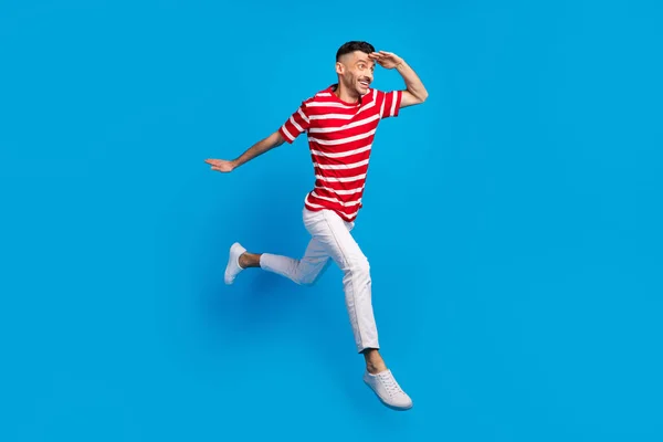 Full-Size-Profil-Seite Foto von hübschen brünetten Mann aussehen verpönt Kopierraum laufen Sprung isoliert auf blauem Hintergrund — Stockfoto