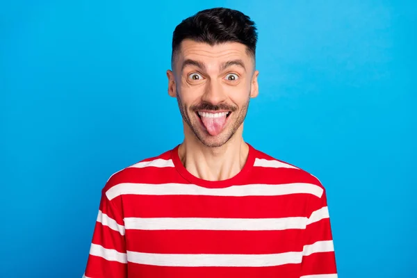 Foto de funky divertido joven feliz hacer lengua cara tonta fuera aislado sobre fondo de color azul pastel — Foto de Stock