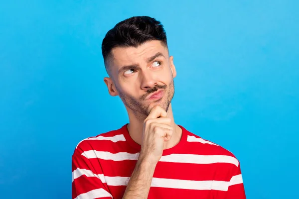 Foto de chico serio reflexivo vestido rojo camiseta brazo barbilla buscando espacio vacío aislado color azul fondo — Foto de Stock