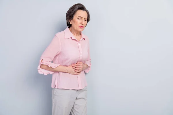 Portrét atraktivní nemocné ženy středního věku pocit špatné bolesti břicha nevolnost izolované přes šedé pastelové barvy pozadí — Stock fotografie