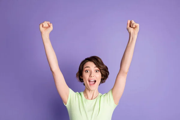 Retrato de chica atractiva alegre de pelo castaño suerte celebrando levantamiento manos arriba aislado sobre fondo de color violeta —  Fotos de Stock