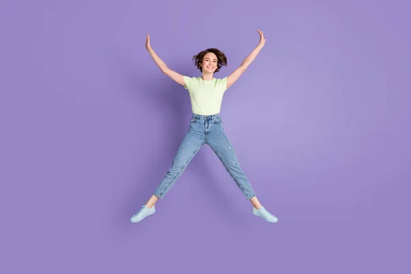 Comprimento total tamanho do corpo vista de linda menina magra alegre pulando se divertindo isolado sobre fundo cor violeta — Fotografia de Stock