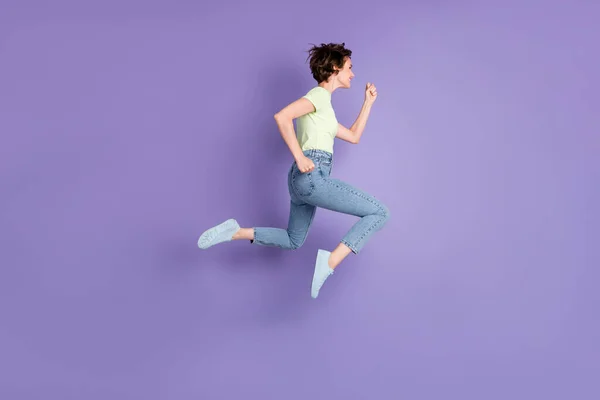 フル長いボディサイズプロフィール側ビューの美しいです陽気なやる気のある女の子ジャンプ実行中に速く分離された紫色の背景 — ストック写真