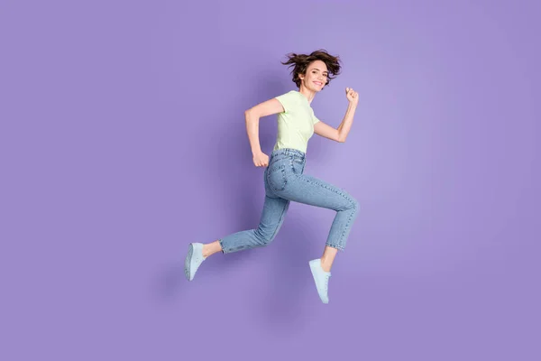 Teljes hossz testméret profil oldalnézetben szép vidám sportos lány jumping futó maraton elszigetelt felett lila színű háttér — Stock Fotó