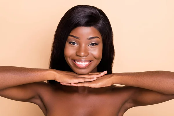 Photo of adorable happy dark skin naked lady hands arms chin smiling isolated beige color background