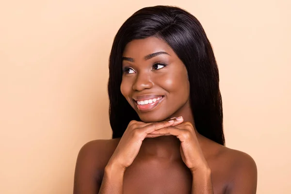 Foto de pele escura doce feliz senhora nua mãos braços queixo sorrindo olhando espaço vazio isolado cor bege fundo — Fotografia de Stock