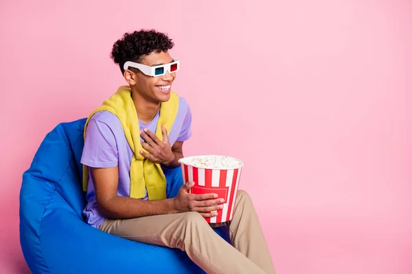 Foto de joven alegre sonriente hombre africano positivo viendo la película en 3-d vasos comer maíz pop aislado en el fondo de color rosa — Foto de Stock