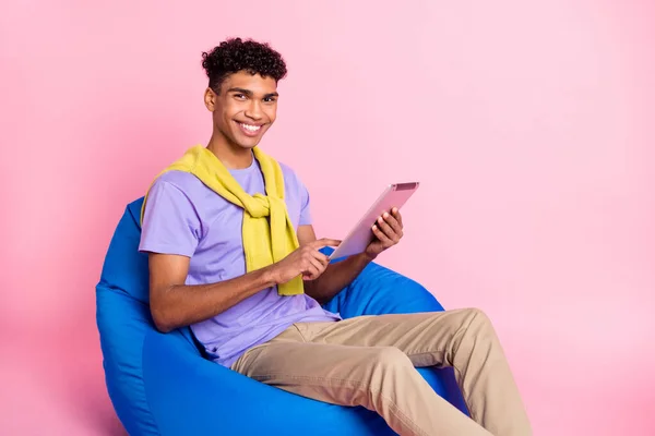 Perfil da foto lateral do jovem afro alegre cara sorriso feliz ler navegar tablet internet isolado sobre fundo cor pastel — Fotografia de Stock