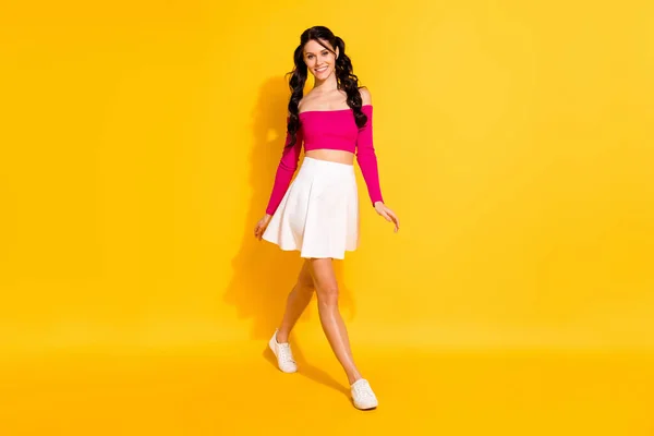 魅力的なかなり若い女性の完全な長さの写真はピンクトップホワイトスカート歩く隔離された黄色の色の背景 — ストック写真
