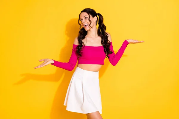 Porträtt av charmiga glada drömmande vågiga hår flicka som håller i handflatorna kopiera utrymme isolerad över ljusa gula färg bakgrund — Stockfoto
