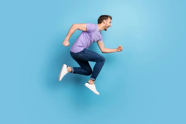 Full length φωτογραφία προφίλ σώματος του νεαρού άνδρα άλμα υψηλό τρέξιμο για την πώληση απομονωμένο σε παστέλ μπλε φόντο χρώμα — Φωτογραφία Αρχείου