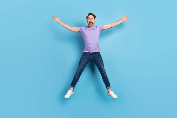 Foto de corpo de comprimento total de jovem pulando gritando alto isolado no fundo de cor azul pastel — Fotografia de Stock