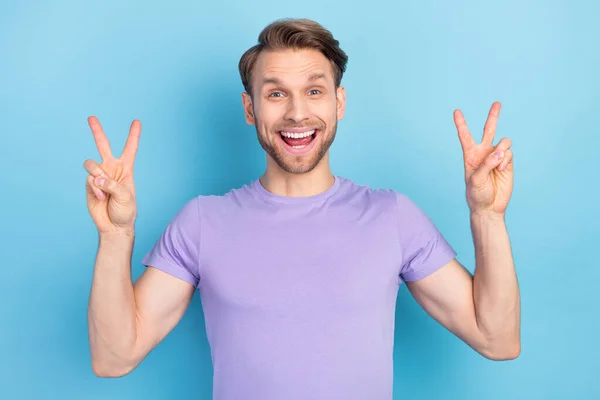 Foto retrato del hombre positivo agradable mostrando gesto v-signo sonriendo aislado sobre fondo de color azul pastel — Foto de Stock