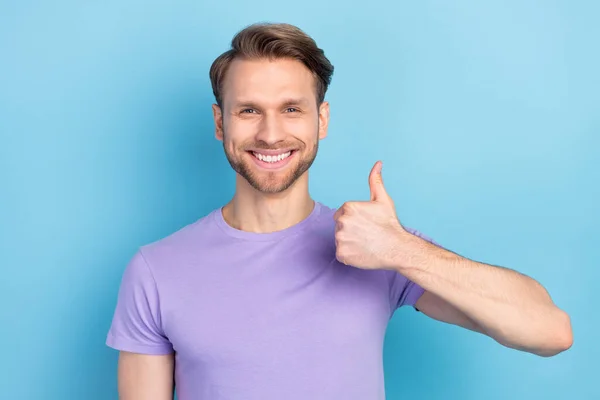 Foto de homem alegre satisfeito radiante sorriso mostrar polegar para cima olhar câmera isolada no fundo de cor azul — Fotografia de Stock