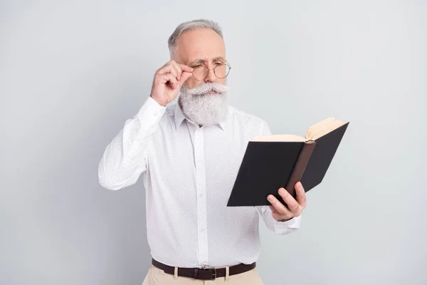 Foto de mentalidad inteligente anciano usar gafas libro rojo novela usar camisa blanca aislada sobre fondo de color gris — Foto de Stock