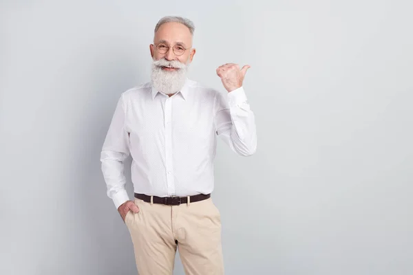 Foto de hombre anciano feliz sonrisa positiva punto pulgar espacio vacío seleccionar sugerir publicidad aislado sobre fondo de color gris — Foto de Stock