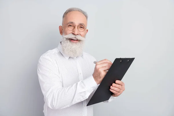 Photo de heureux joyeux vieil homme attrayant écrire presse-papiers plan gestionnaire isolé sur fond de couleur grise — Photo