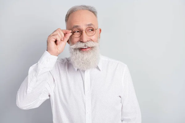 Foto di invecchiato uomo d'affari felice positivo sorriso mano toccare occhiali sguardo vuoto spazio isolato su sfondo di colore grigio — Foto Stock