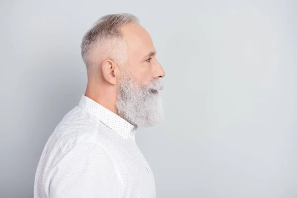 Profil sida foto av allvarliga lugn fridfull gammal man ser tomt utrymme bära vit skjorta isolerad på grå färg bakgrund — Stockfoto