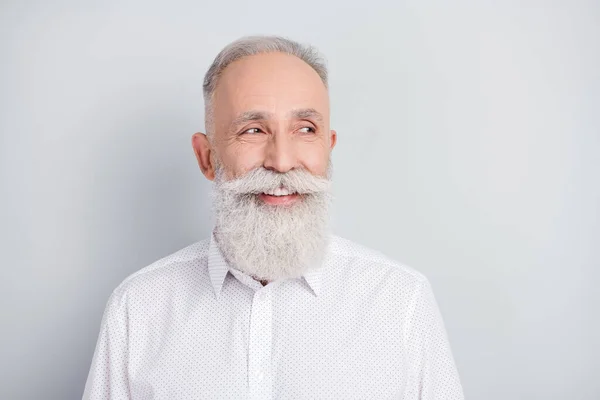 Foto di bello allegro capelli grigi vecchio sguardo vuoto spazio indossare camicia bianca isolato su sfondo di colore grigio — Foto Stock