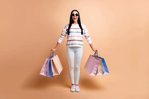 Full body foto van jong opgewonden meisje gelukkig positieve glimlach winkel zwart vrijdag tassen geïsoleerd over beige kleur achtergrond — Stockfoto