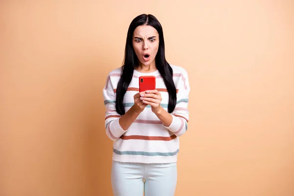 Foto di giovane scioccato stupito ragazza sorpresa vedere antipatia in smartphone indossare pantaloni bianchi isolati su sfondo di colore beige — Foto Stock