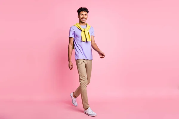 Full size foto van mooie optimistische brunette kerel ga dragen t-shirt broek geïsoleerd op roze kleur achtergrond — Stockfoto