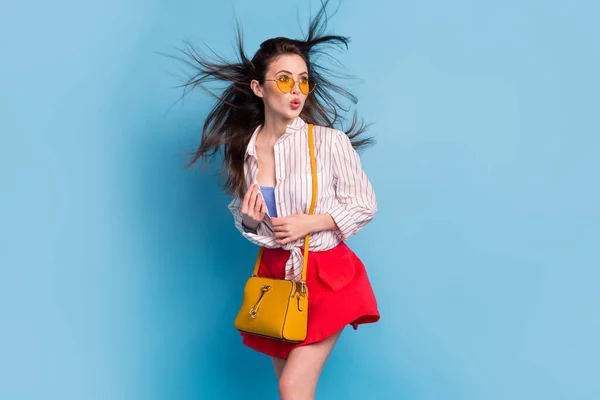 Retrato de atractivo glamoroso sorprendido chica funky pucheros labios buen humor viento soplado pelo aislado sobre brillante azul color de fondo — Foto de Stock