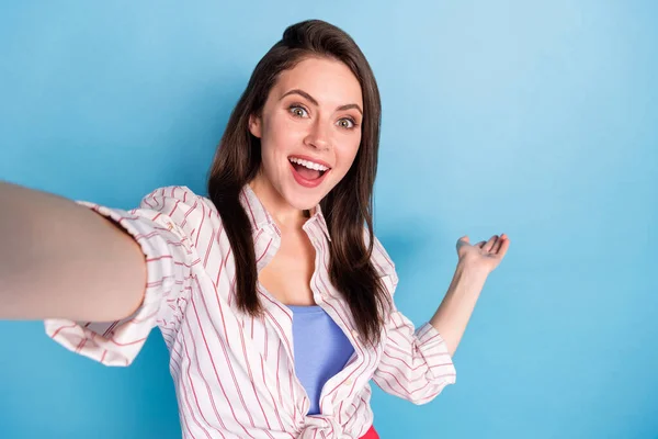 Çekici pozitif kadının portresi, selfie kolu avuç içi boşluğu mavi arkaplanda izole eder. — Stok fotoğraf