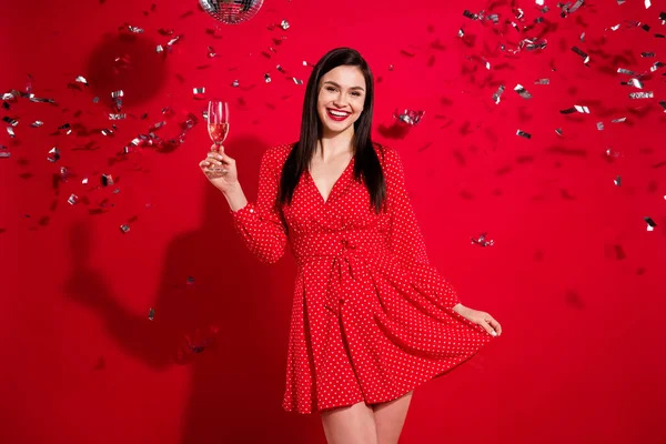 Foto de elegante impresionado morena dama celebrar vidrio bebida desgaste vestido rojo aislado sobre fondo de color vivo —  Fotos de Stock