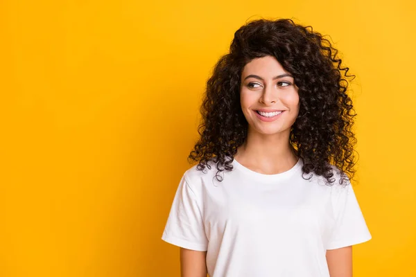 Foto de joven atractiva hermosa sonrisa alegre chica positiva en blanco camiseta mirada copyspace aislado sobre fondo de color amarillo —  Fotos de Stock