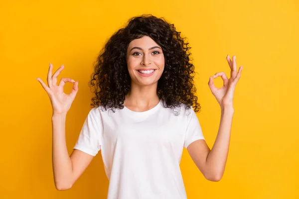 Foto av unga leende glad positiv vacker vacker flicka visar okej tecken bära vit t-shirt isolerad på gul färg bakgrund — Stockfoto