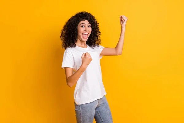 Foto de joven feliz loco excitado positivo sonriente alegre chica levantar los puños en la victoria aislado sobre fondo de color amarillo — Foto de Stock