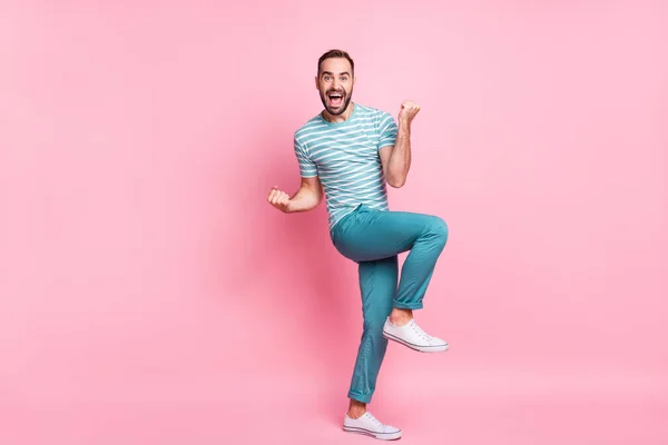 Volledige lichaamsomvang uitzicht van aantrekkelijke succesvolle vrolijke jongen dansen met plezier vieren overwinning geïsoleerd over roze pastel kleur achtergrond — Stockfoto