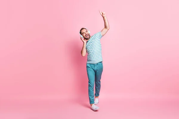 Volledige lichaamsomvang uitzicht van mooie vrolijke man wandelen genieten van luisteren melodie hebben plezier rust geïsoleerd over roze kleur achtergrond — Stockfoto