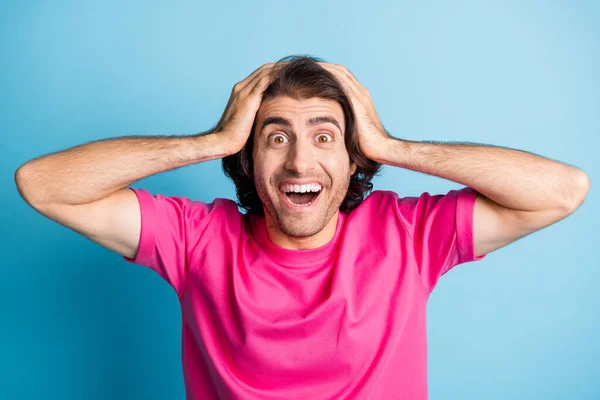 Foto di allegro bello bruno capelli arabo ragazzo bocca aperta mettere le mani sulla testa usura rosa t-shirt isolato su sfondo blu — Foto Stock