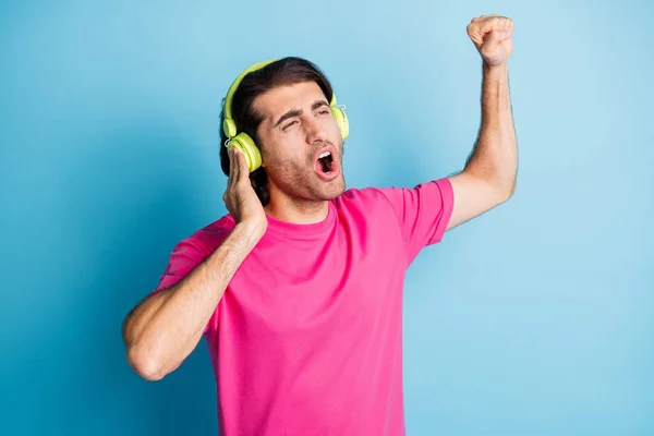 Portret van aantrekkelijke vrolijke man fan meloman genieten van luisteren single zingen hit geïsoleerd over helder blauwe kleur achtergrond — Stockfoto