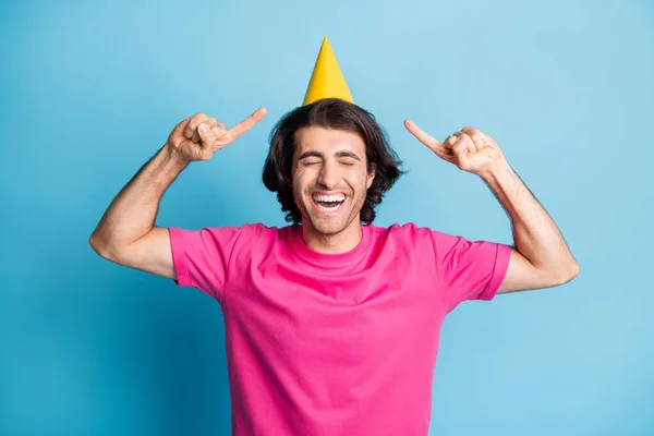 Πορτρέτο του ελκυστικό χαρούμενο ονειρικό χαρούμενος τύπος φορώντας δείχνει festal καπάκι απομονώνονται πάνω από φωτεινό μπλε χρώμα φόντο — Φωτογραφία Αρχείου