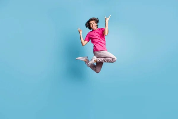 stock image Full length body size view of attractive cheerful funky cool hipster jumping showing horn symbol isolated over vivid blue color background