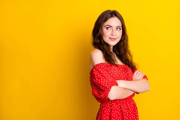 Foto retrato de senhora bonita com as mãos cruzadas sorrindo em vestido vermelho olhando espaço em branco isolado vibrante cor amarela fundo — Fotografia de Stock
