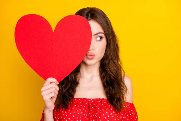 Foto de adorável senhora mão segurar coração símbolo cartão postal beijo lábios olhar espaço vazio isolado no fundo cor amarela — Fotografia de Stock