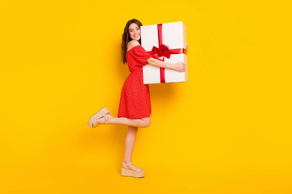 Full size profile portrait of positive charming lady hands hold large giftbox isolated on yellow color background — Stock Photo, Image