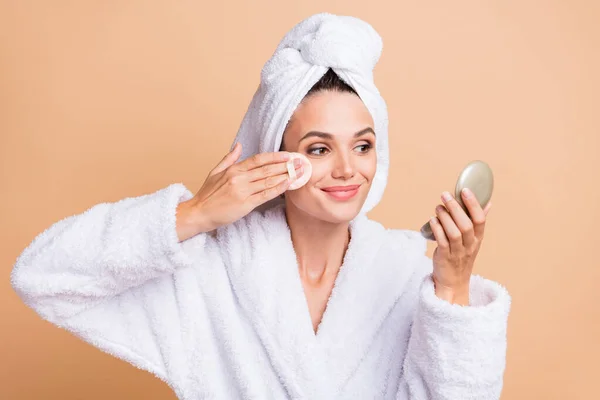 Foto de encantadora hermosa mujer joven aplicar polvo mantenga espejo aislado sobre fondo de color beige pastel — Foto de Stock