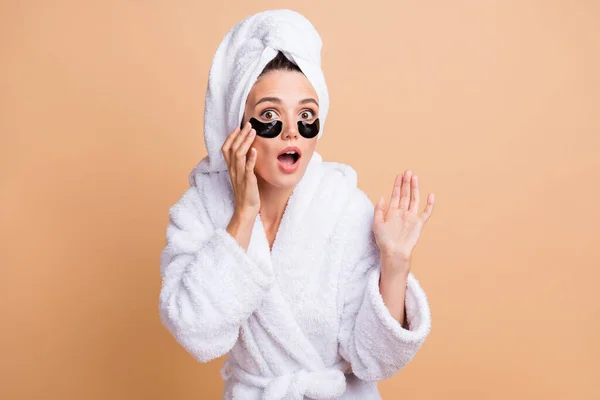 Foto de medo espantado jovem mulher toque tratamento facial usar manchas oculares isoladas no fundo cor bege — Fotografia de Stock