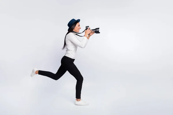 Полный профиль тела боковой фото счастливой молодой женщины бегать пустое пространство сфотографировать папарацци изолированы на сером фоне цвета — стоковое фото