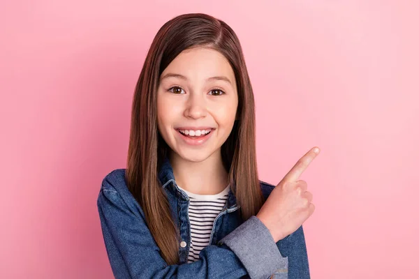 Foto retrato de menina pequena apontando o dedo no espaço em branco isolado no fundo cor-de-rosa pastel — Fotografia de Stock