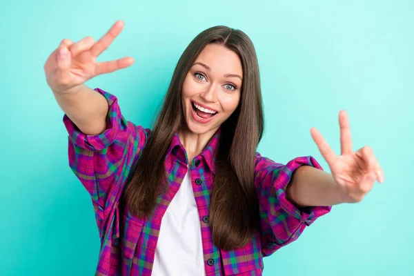 Photo of lovely long hairdo millennial lady show v-sign nosić w kratkę koszula izolowane na żywe ciemne tło — Zdjęcie stockowe